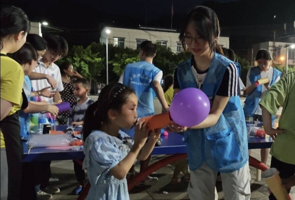 志愿者和小朋友一起体验“火箭”升空。重庆师范大学物理与电子工程学院供图