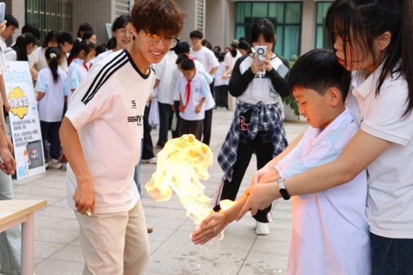 小朋友们在室外广场体验“火焰掌”实验。重庆师范大学供图