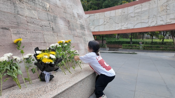 屈美芸在烈士纪念碑前献花。重庆师范大学美术学院供图